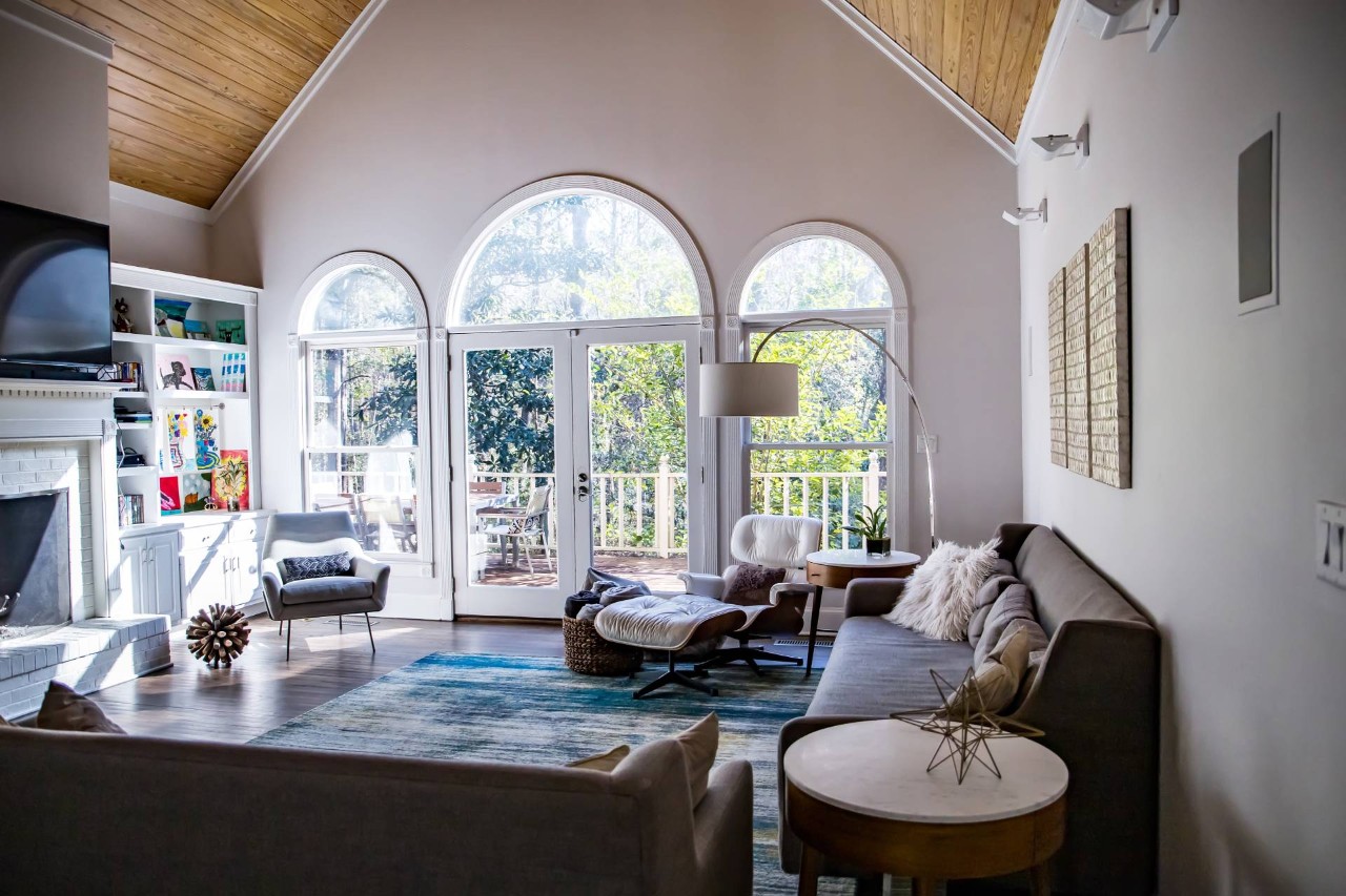 Living room with vaulted ceilings, neutral couches, and arched windows above two windows and French doors at Eagle Harbor Window Coverings near Bainbridge Island, Washington (WA)