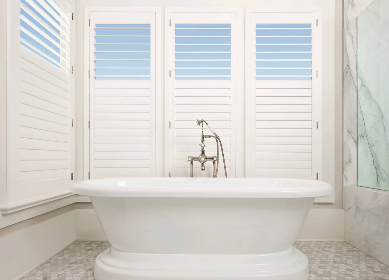 Bathroom with a tub and Hunter Douglas shutters open at the top and closed at the bottom at Eagle Harbor Window Coverings near Bainbridge Island, WA